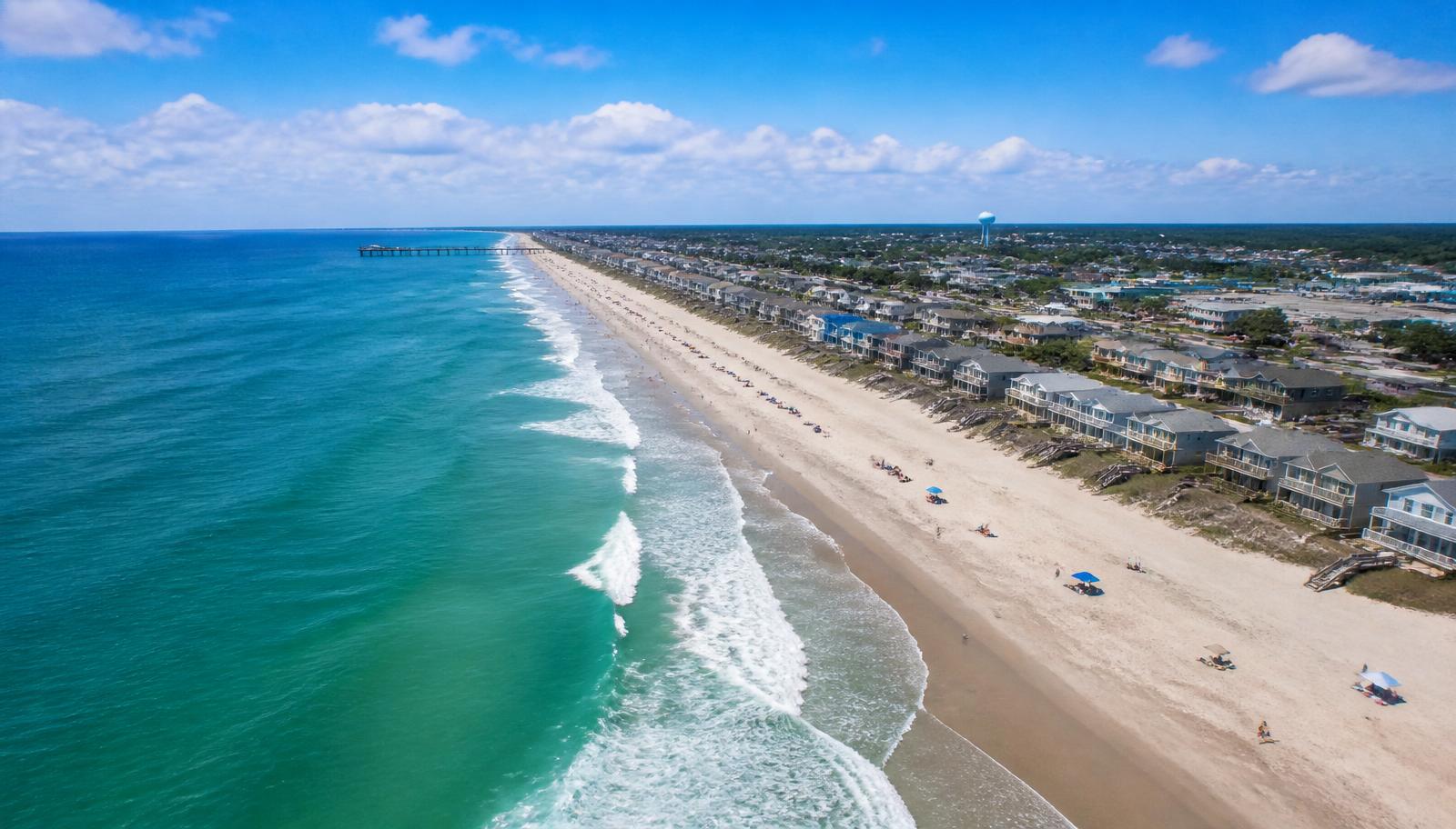 Aerial view of Carolina Beach shoreline with vacation homes and turquoise ocean water